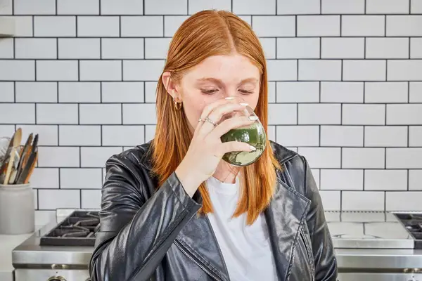 Person drinking a glass of AG1 by Athletic Greens