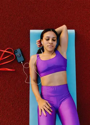 person listening to music on yoga mat