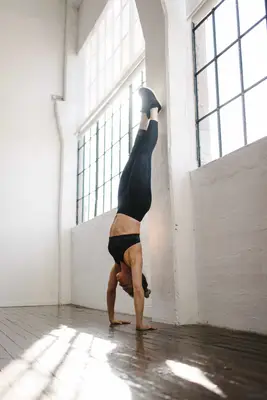 Female athlete doing handstand in gym
