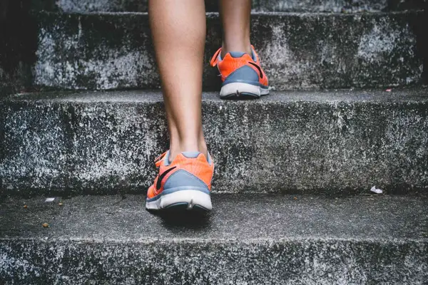 Person wearing gym sneakers climbing stairs
