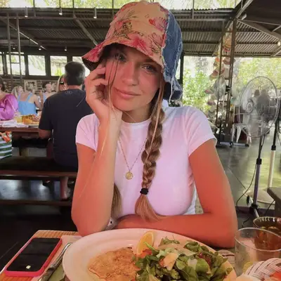 Josephine Skriver eating with bucket hat on