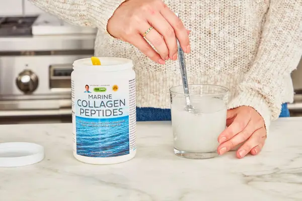 Woman mixing Procaps Marine Collagen Peptides powder into a glass of water