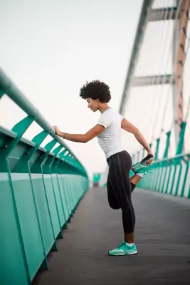 woman on bridge stretching