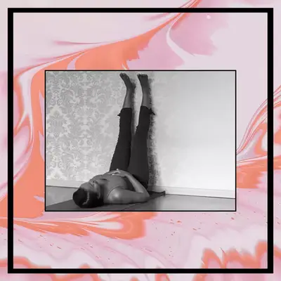 woman with legs on wall stretching to relieve bloating