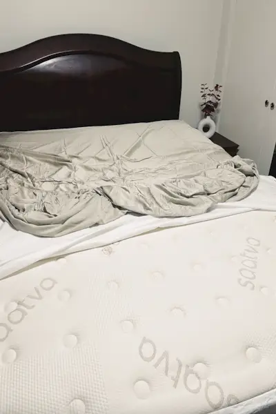 un lit avec un drap blanc