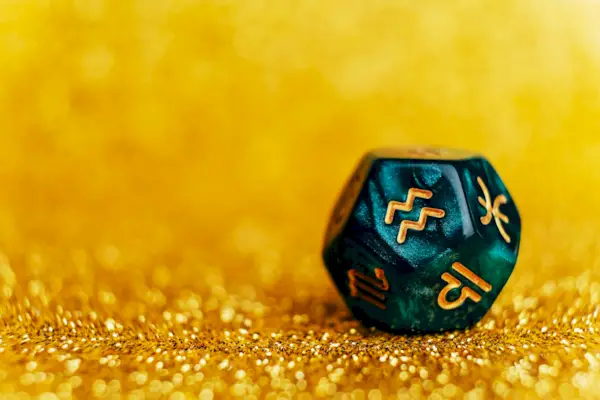 Glowing green divination dice Aquarius on gold colored background.