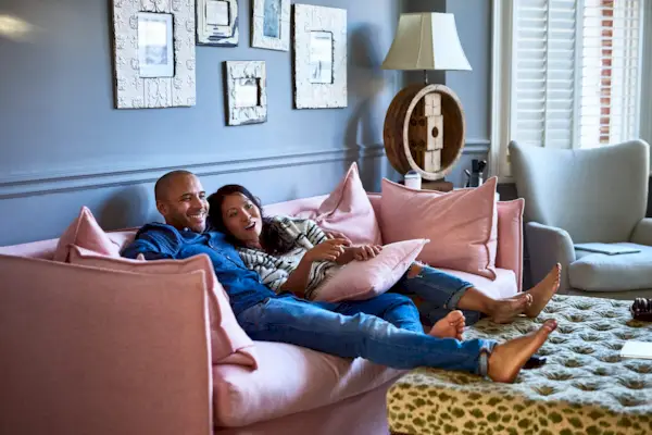 Couple at home watching television together on sofa
