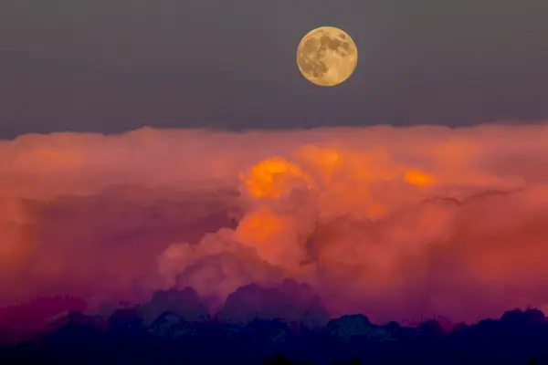 Harvest moon rising above storm clouds, western Colorado.