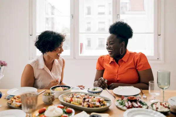 Happy Diverse Friends Sitting At The Table And Talking To Each Other