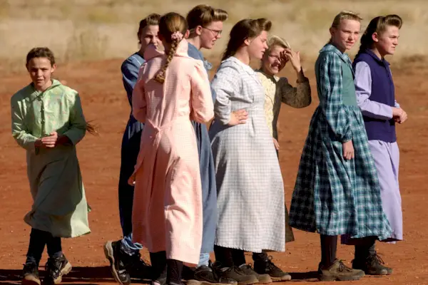 01_22_04_COLORADO CITY, ARIZONA-School children dressed in the traditional garb of the FLDS play after school in an open field. The men wear trousers and shirts buttoned up to the very top of the collar. Women must wear their long hear back, tied on top o