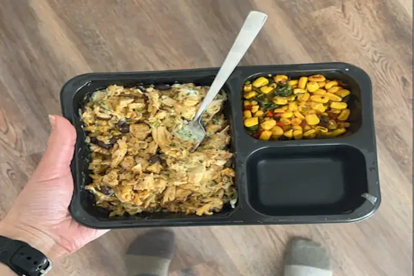 uma pessoa segurando um garfo e um recipiente com comida