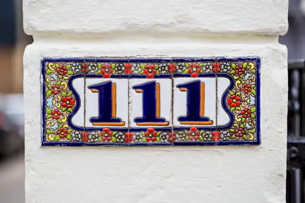 Sign on a wall for a property with street number 111