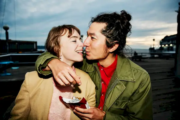 Smiling couple sharing piece of chocolate while on date