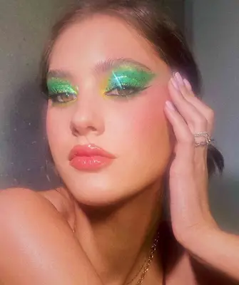 model is wearing a bright green glitter eyeshadow look