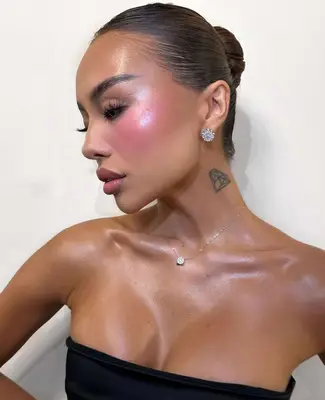 model wears a vivid pink blush with beautiful highlight on the apples of the cheeks