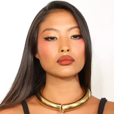 Model with warm-toned skin and makeup and brick-colored lipstick with brown liner