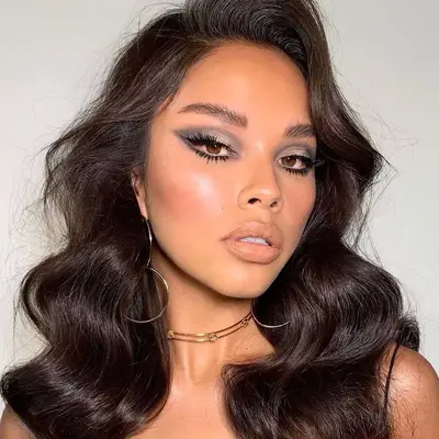 woman with 1970s style waves and bold silver makeup