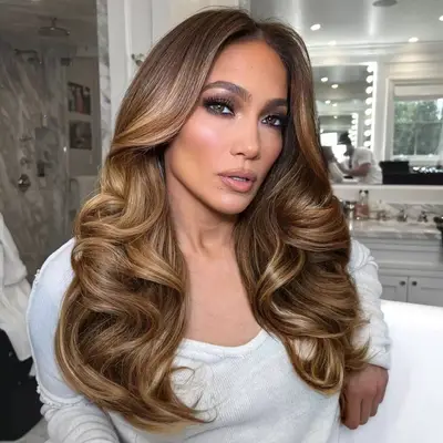 J. Lo with center parted waves and deep purple eye makeup
