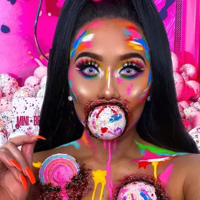 Makeup artist wears colorful face paint in Halloween Jawbreakers-inspired look