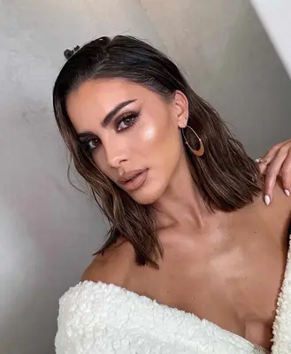 model poses wearing a smoky eye and nude lip and cheek