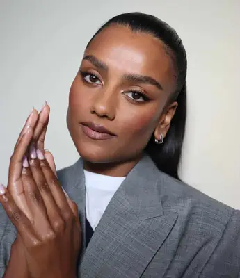 model poses wearing soft glam nude makeup look