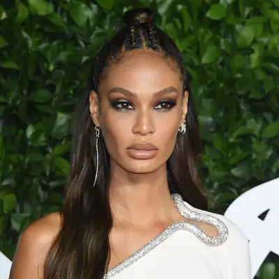 Joan Smalls wearing blue eyeshadow and a white dress at the 2019 Fashion Awards in London, England