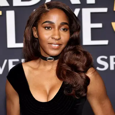 Ayo Edebiri with mocha mousse makeup and a black dress at the 2025 SNL50 event in New York City