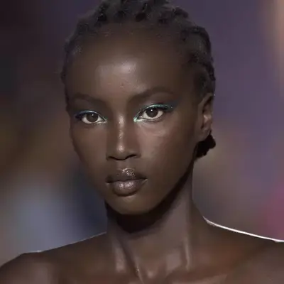 Anok Yai with blue green glitter eyeliner