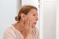 Woman rubbing Too Faced Hangover Primer onto her cheek