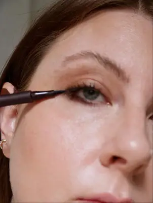 Ashley Rebecca adds liquid liner to her eyes