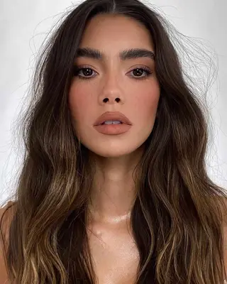 Woman with wavy hair wearing nude lip with liner