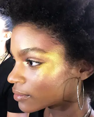 Close-up of woman wearing gold facial glitter and lip gloss