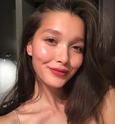 Woman wearing cream brush and pink lipstick