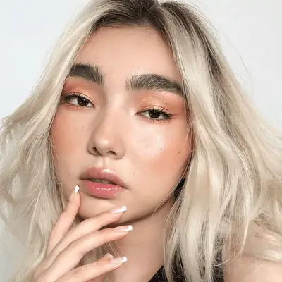 model wearing golden bronze eyeshadow and peach blush