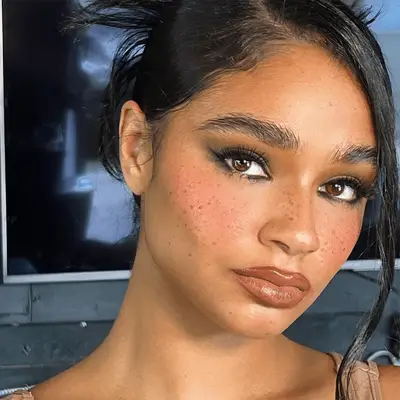 model wearing rosy blush, smoky eyeshadow, and brown lipstick