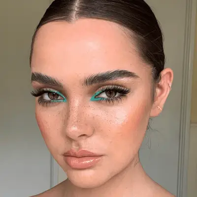 model wearing teal eyeshadow and slick bun