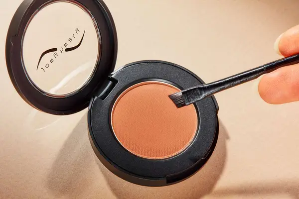 A person applies Joey Healy Luxe Brow Powder