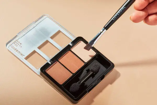 A person applies CoverGirl Easy Breezy Brow Powder Kit
