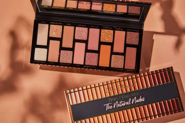 Too Faced Born This Way The Natural Nudes Eye Shadow Palette displayed on a beige background 
