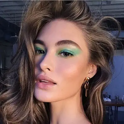 Grace Elizabeth with emerald green eyeshadow, blue eyes, and neutral makeup