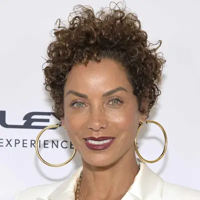 Nicole Murphy wears subtle shimmery eyeshadow, mascara, and berry-toned lipstick