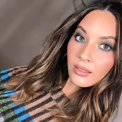 Olivia Munn wears blue and green eyeshadow with neutral lipstick and blush