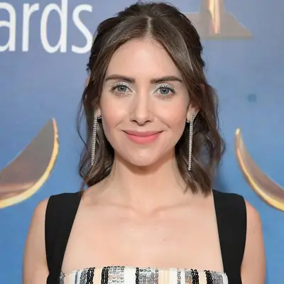 Alison Brie with silver eyeshadow, peach lipstick, and glowing skin