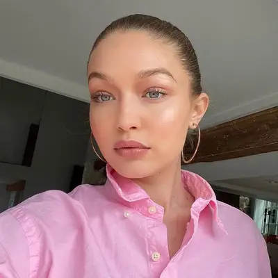Gigi Hadid with peach eyeshadow, blue eyes, and radiant makeup look