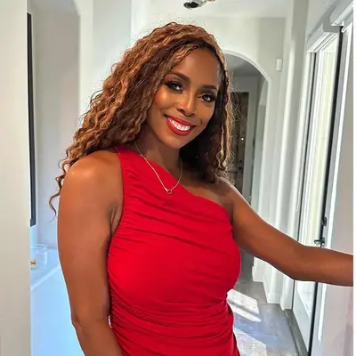 Woman with curly hair and bright red lipstick.