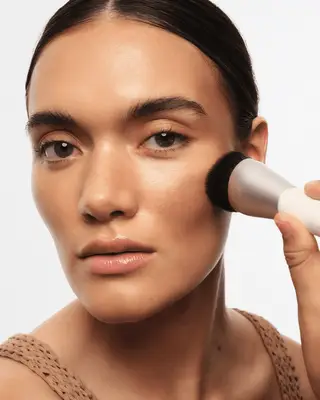 model applying the Goop bronzing gel