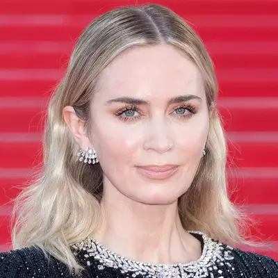 Emily Blunt with blonde waves and s-shaped eyebrows attends the 