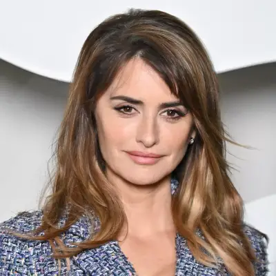 Penelope Cruz with long eyebrows, caramel highlights, and blue tweed suit attends the Chanel Womenswear Fall Winter 2023-2024 show as part of Paris Fashion Week