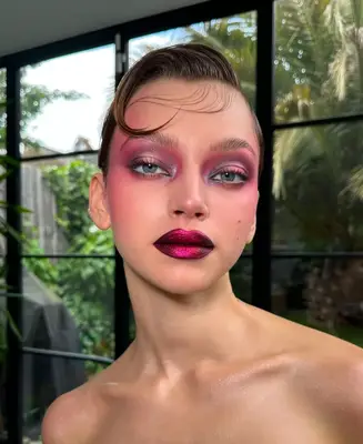 model wears dramatic pink makeup look with metallic lips