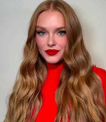 Abbey Cowen wears bold matte red lipstick and winged eyeliner